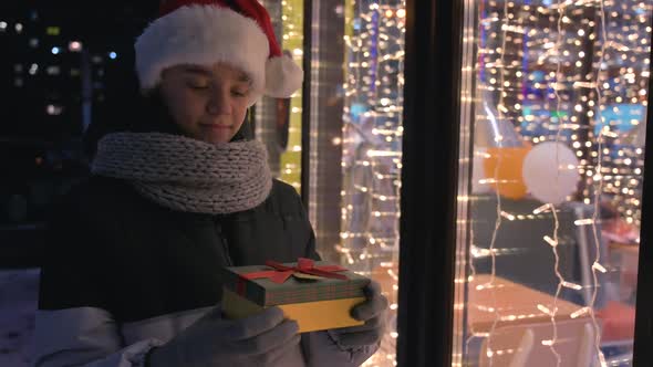 Boy in Santas Hat with Gifts Box Looking and Dreaming