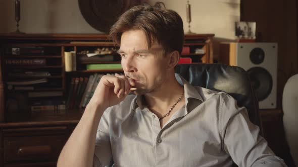 a Man Thinks with His Hand to His Mouth About a Serious Broadcast About a Great Idea in His Room alt