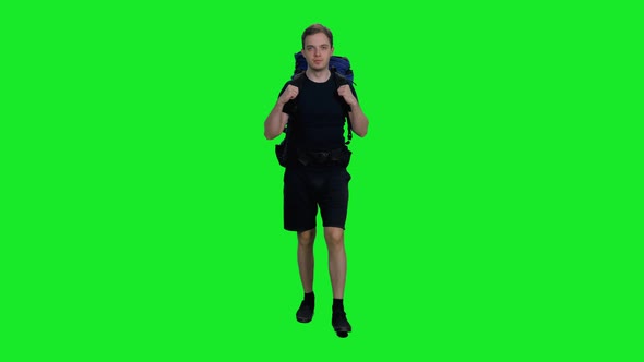 Young Camper in Black T-shirt and Shorts Walking with Backpack Against Green Screen Background