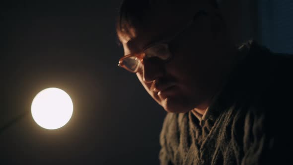 A Male Student Is Sitting at Desk, Writing Down Notes From Opened Textbook. Young Man Is Preparing alt