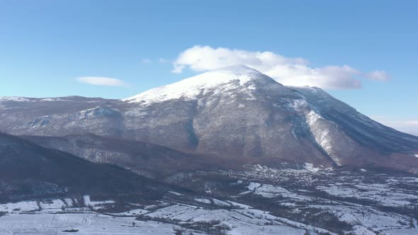 Top of the mountain Rtanj in snow and clouds 4K aerial video alt