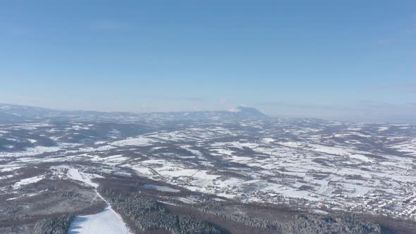 Rtanj mountain over the snowed valley 4K aerial video alt