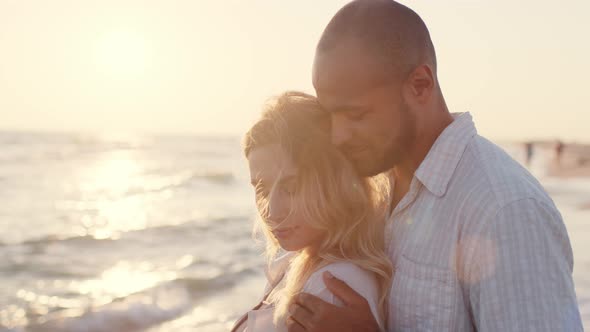 Young Beautiful Couple in Love Standing and Hugging on Beach By the Sea