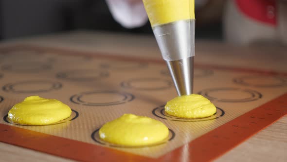 Pastry Chef Is Cooking Macaroons. Pouring Dough on Stencil Silicone Mat alt