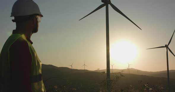 The Young Engineer Examines the Windmill and Then Turns to the Camera Throwing His Hands on Each alt