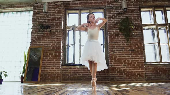 Young Ballerina in White Tutu and Ballet Shoes is Practicing Dance Moves alt