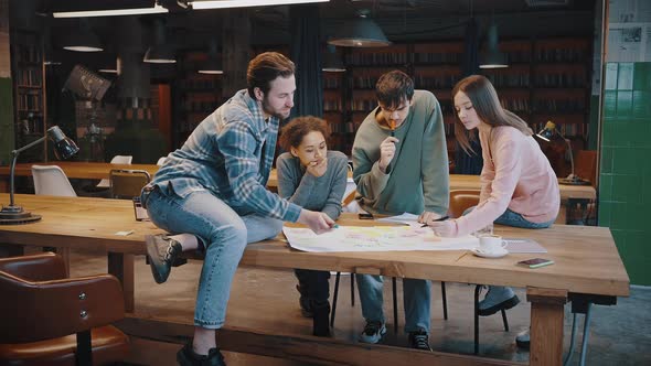 Multiethnic Young Students Prepare Scientific Research at Library in Team alt