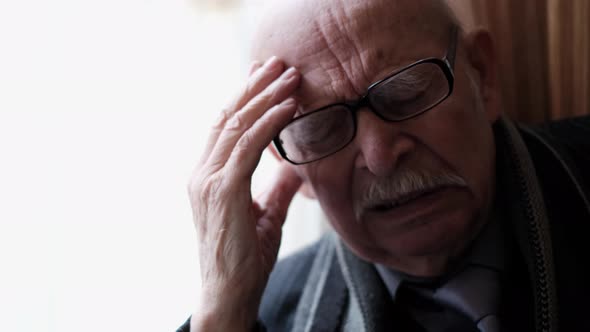 Close Up Portrait of Elderly Grandfather with Headache Senior Pensioner at Home alt