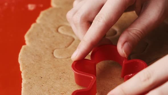 Cutting Out Gingerbread Cookies in the Shape of Gingerbread Men From the Dough for Christmas Party alt