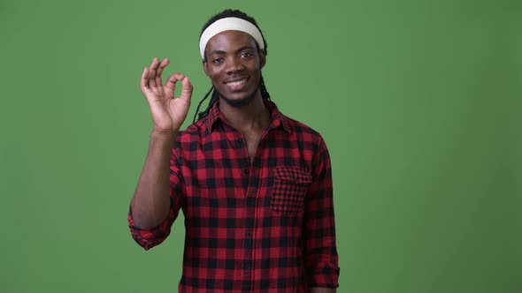 Young Handsome African Man with Dreadlocks Against Green Background alt