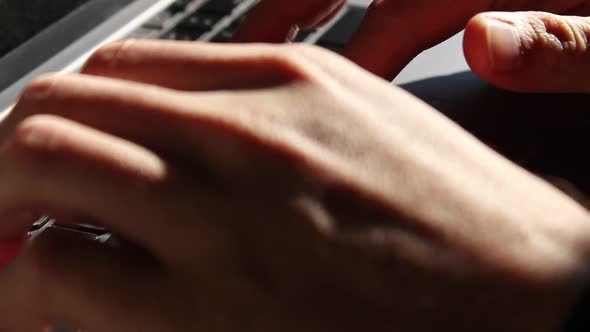 Caucasian person typing on laptop keyboard. Static close up shot alt
