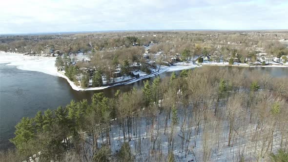Sliding Drone shot of summer and winter houses surrounding a lake alt