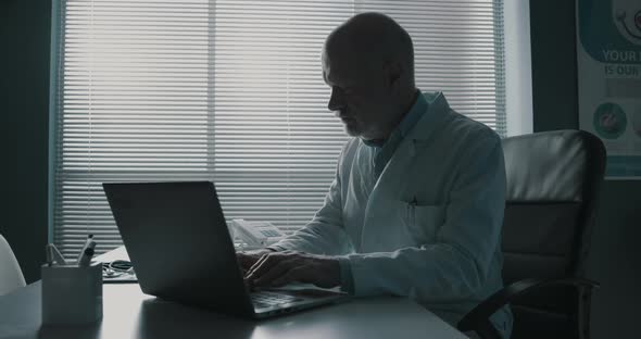 Professional doctor typing on a laptop