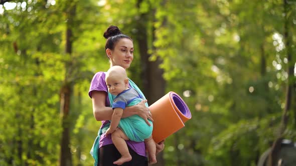 Yoga Woman Going To Outdoor Training with Baby in Sling alt