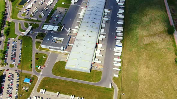 Trucks with semi-trailers stand on the parking lot of the logistics park with loading hub and wait f alt