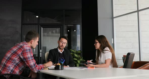 Creative Team of a Business Meeting in a Modern Starting Office Discussing Ideas for the Development alt