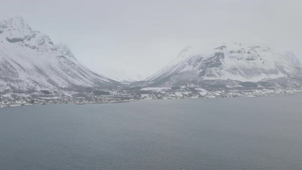 Aerial drone push in towards snow covered Olderdalen, Northern Norway. alt