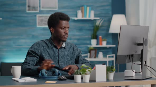 African American Black Manager Using Headphones to Listen Music While Working From Home Office on alt
