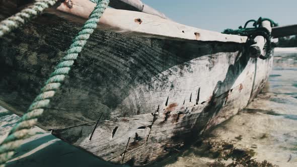 Old Dry African Fishing Rowboat Stranded in Sand on Beach at Low Tide Zanzibar alt