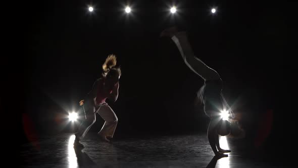 Girls Are Practicing Capoeira in Darkness Against Spotlight alt