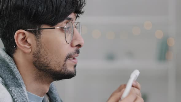 Closeup Male Face Side View Sick Arabic Hispanic Man Bearded Guy with Glasses Wrapped in Blanket alt