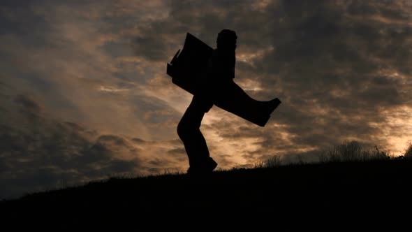 Pilot or Aviator Man Silhouette Plays Running Outdoor with His Carboard Airplane