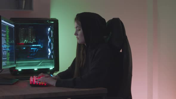 Girl Hacker Typing at the Computer alt