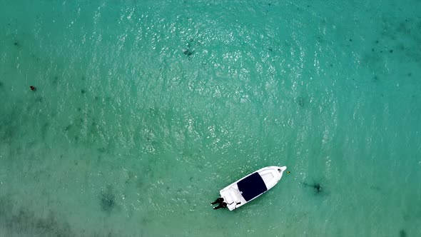 Aerial birds eye shot of anchored luxus speedboat on crystal clear ocean surface alt