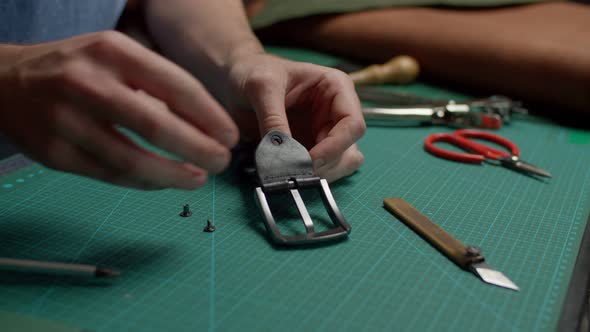 Craftsman Getting Pieces of Disassembled Leather Belt Together Indoors alt