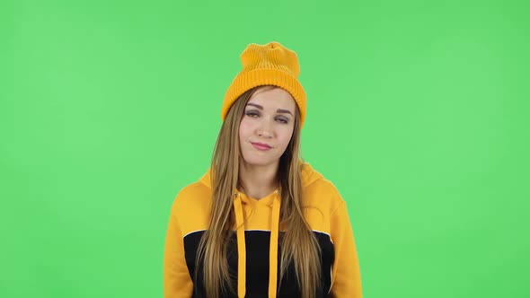 Portrait of Modern Girl in Yellow Hat Is Waiting and Yawning with Boredom. Green Screen alt