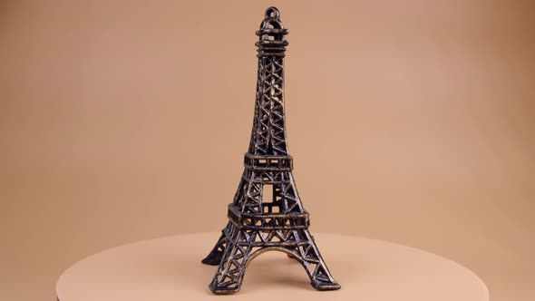 Rotating Miniature or Souvenir of the Eiffel Tower on a Beige Background