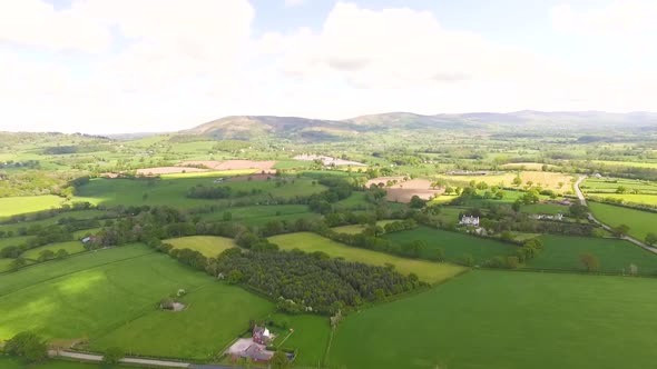 aerial view of agricultural farmland looking out towards hills in the distance. alt