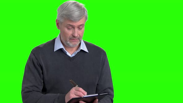 Mature Man Writing on Clipboard. alt