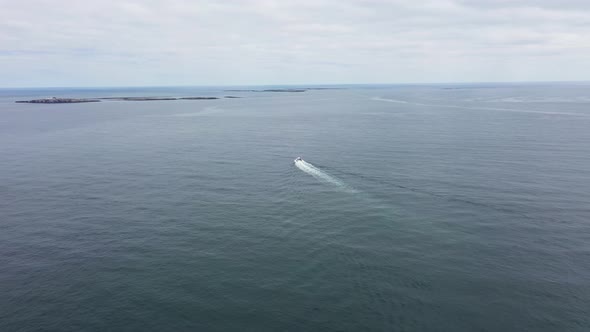 Aerial footage of the seaside coastal town of the village of Seahouses in UK showing a speed boat