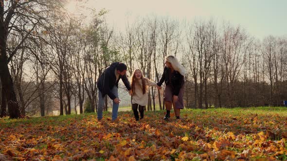 Full family hugging in autumn park. Three persons having fun at nature outdoors alt