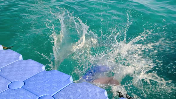 A Funny Man in a Shirt Socks and Shorts Sits on the Pier Then Falls Into the Sea alt