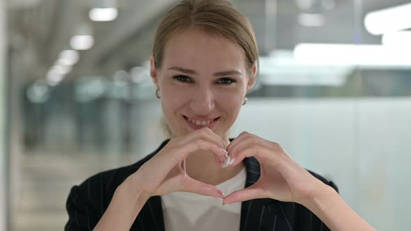 Portrait of Businesswoman Showing Heart Sign with Hand alt