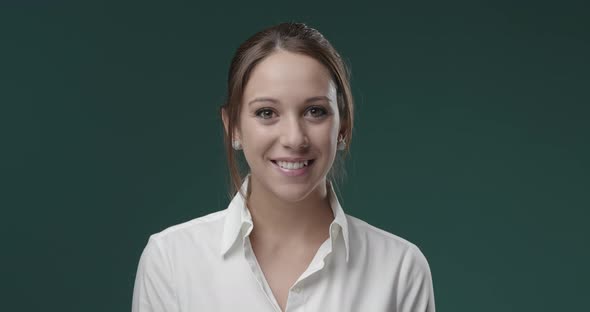 Happy young woman in white shirt, she is smiling at camera