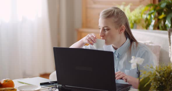 Smiling Woman Working on Laptop at Home Office. Businesswoman Typing on Computer Keyboard. alt