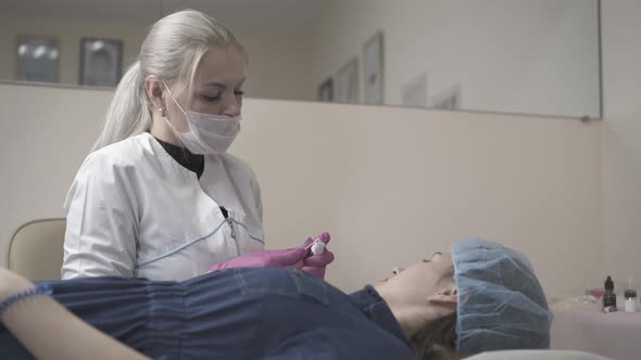Brows Master Applies Paint on Client Hand Before Tattooing alt