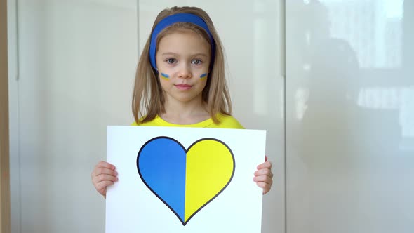 Girl Holds Poster with Heart of Ukraine Flag