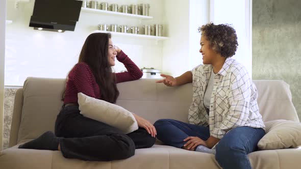 Slow Motion Two Girlfriends an AfricanAmerican and an Asian Chatting with Each Other While Sitting alt