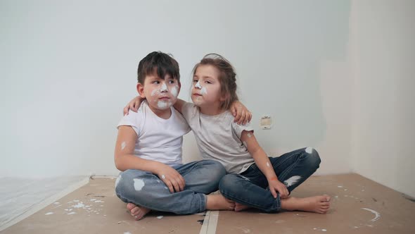 Caucasian Kids Paint the Walls Boy and Girl Took a Break and Have Fun Children's Faces are Painted alt