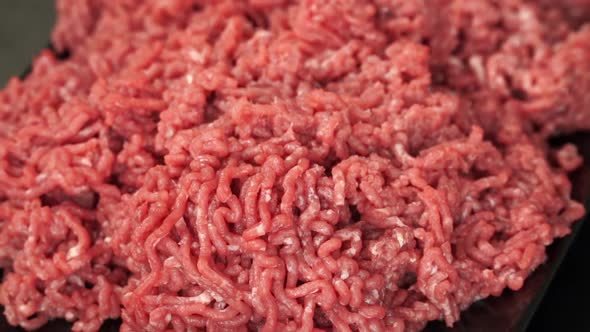 Fresh Ground Beef Rotates on Black Plate Fork Touches Minced Meat