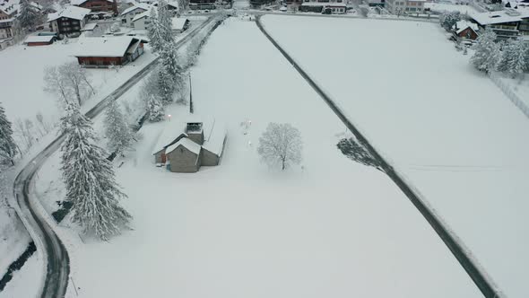Aerial of beautiful small church covered in snow alt