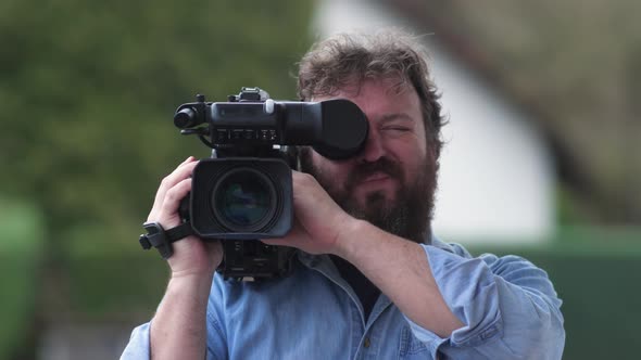 Bearded Television Cameraman Filming Outdoors