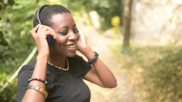 Attractive Happy Smiling Young Natural Beauty Short Haired African Black Woman with Blue Headphones