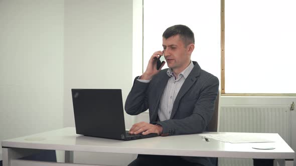 Adult Businessman Talking on Phone in Office