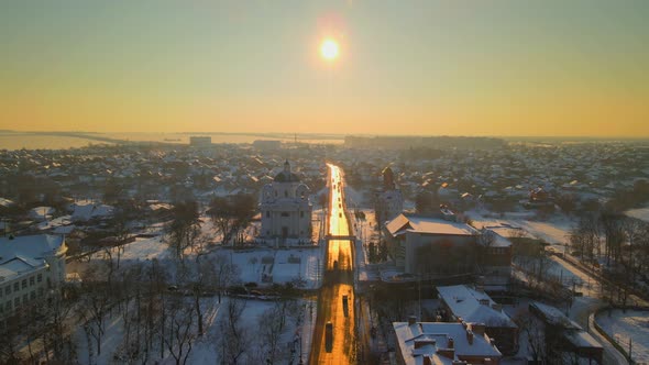 Drone Fly Above Road at Snow Covered Small European City in Winter Sunset HDR alt