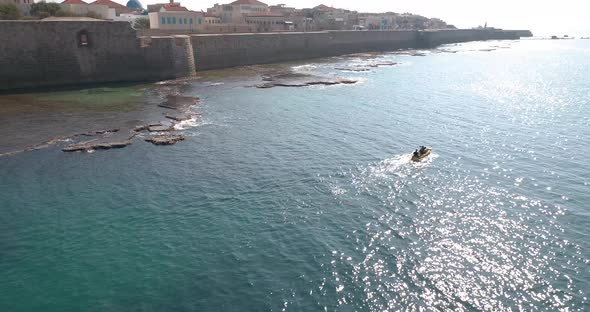 Aerial view of a person doing kayak along the shore, Old City of Acre, Israel. alt